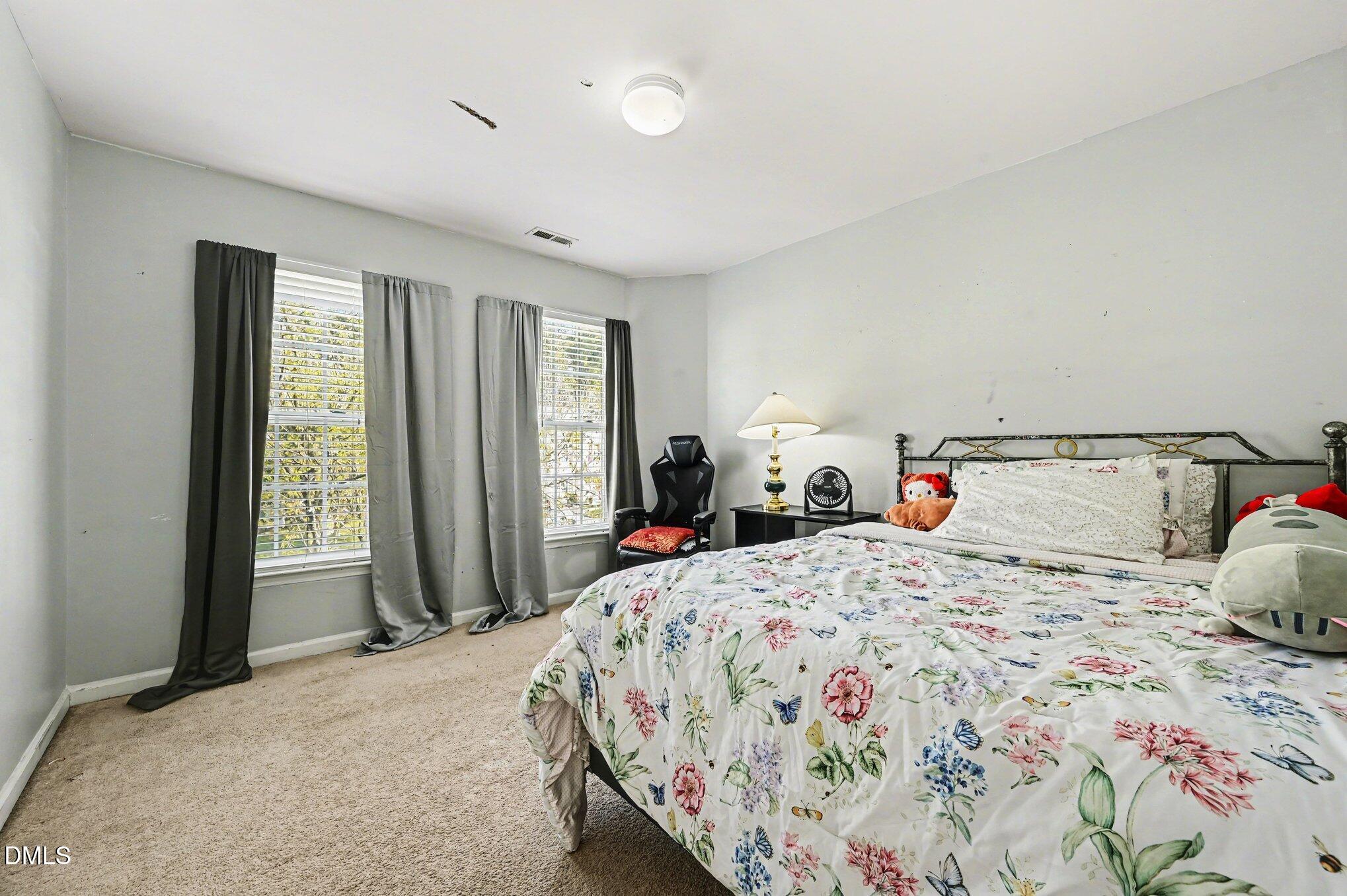 5115 Cardinal Grove Boulevard Raleigh, NC 27616 - Photo 13 of 36 a bedroom with a bed and large windows