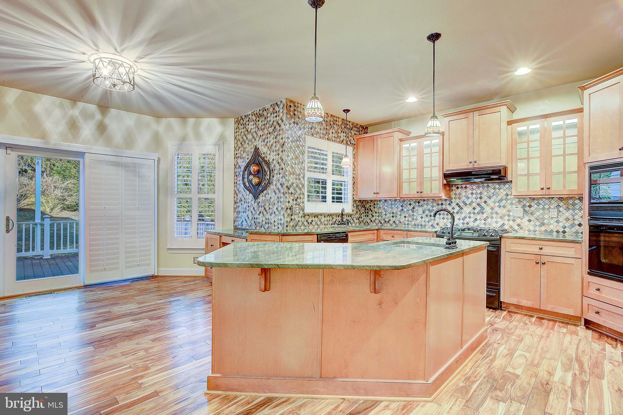 3300 Holland Cliffs Road Huntingtown, MD 20639 - Photo 43 of 93 a large kitchen with kitchen island a stove a sink a center island and wooden floor