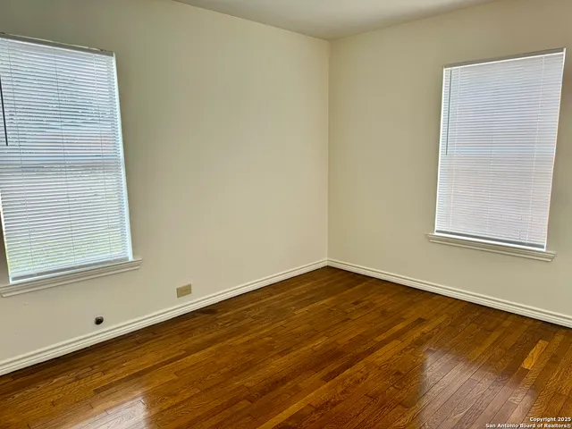 a view of a room with wooden floor and a window
