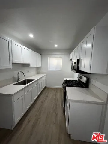 a kitchen with granite countertop a sink and a stove top oven