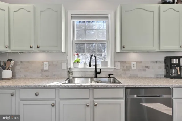 a open kitchen with stainless steel appliances granite countertop a dining table chairs and granite counter tops