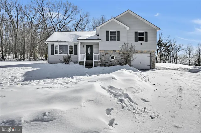 a view of a white house with a yard covered in snow