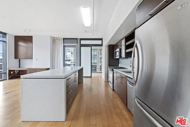 a kitchen with sink a refrigerator and wooden floor