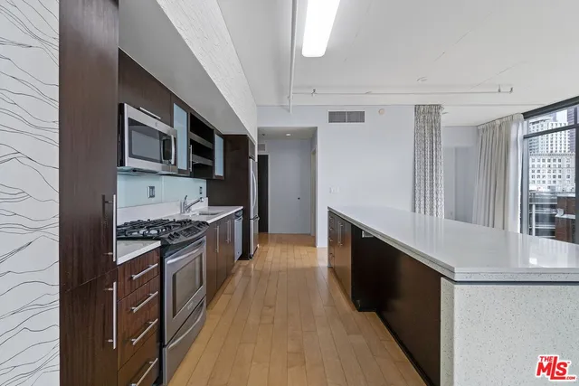 a large kitchen with stainless steel appliances granite countertop a stove and a sink
