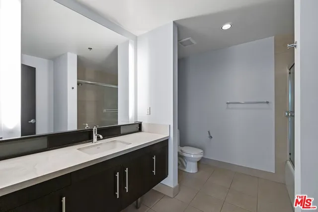 a bathroom with a double vanity sink toilet and a mirror