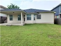 a view of a white house with a big yard and large window