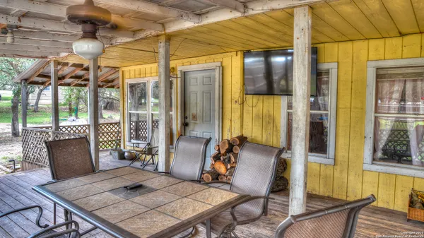 a view of an outdoor dining space with wooden floor and glass windows