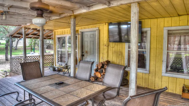 a view of an outdoor dining space with wooden floor and glass windows