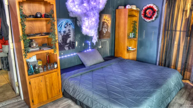 a bedroom with a bed and a painting on the wall