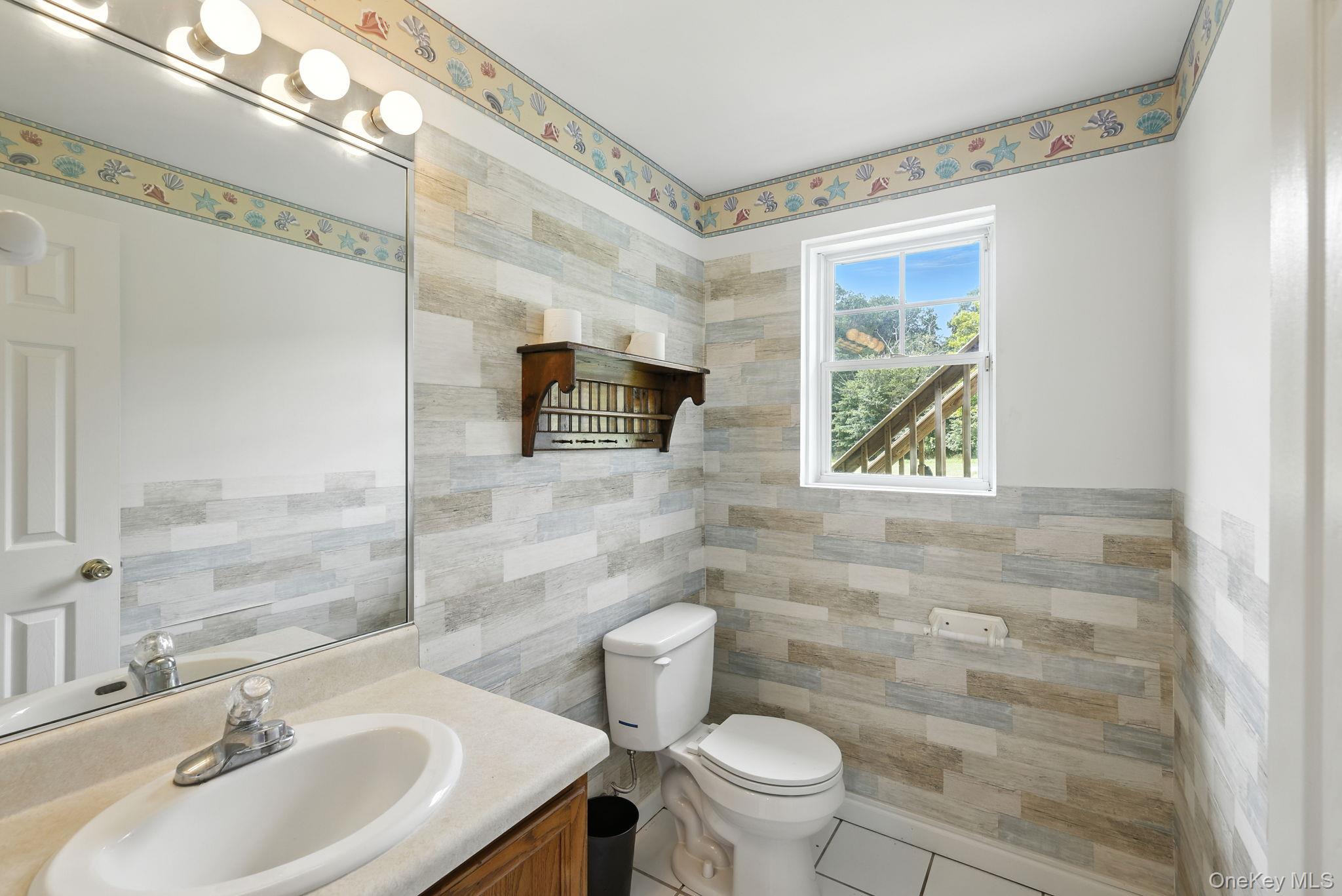 160 Pirog Road Pine Bush, NY 12566 - Photo 18 of 26 Half bathroom featuring vanity, tile patterned floors, and tile walls