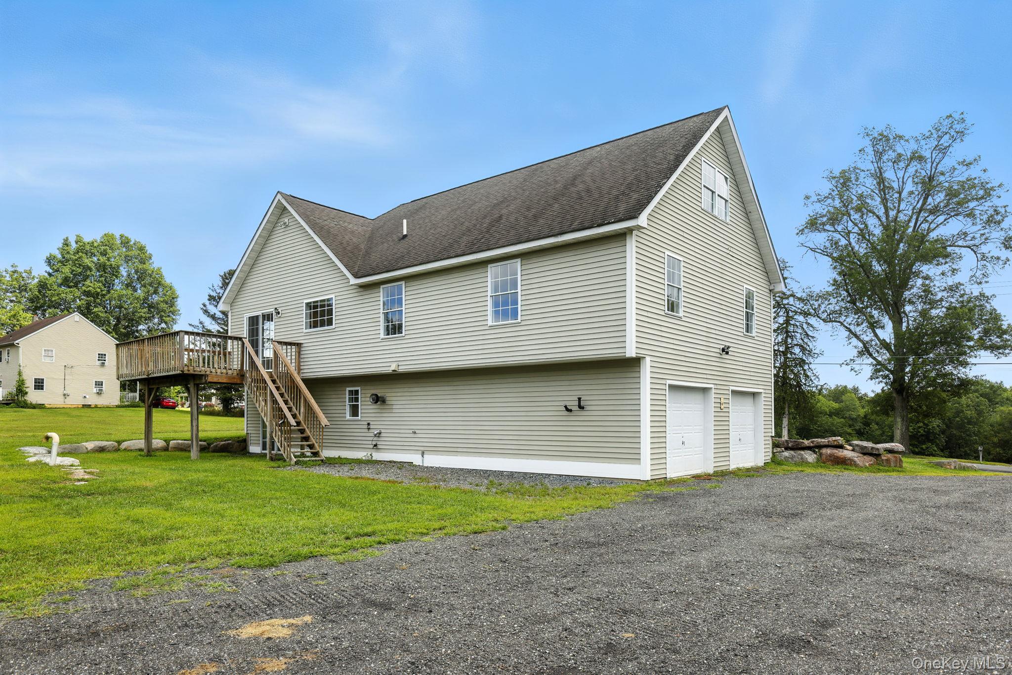 160 Pirog Road Pine Bush, NY 12566 - Photo 23 of 26 Back of property featuring an attached garage, stairs, a wooden deck, a lawn, and roof with shingles