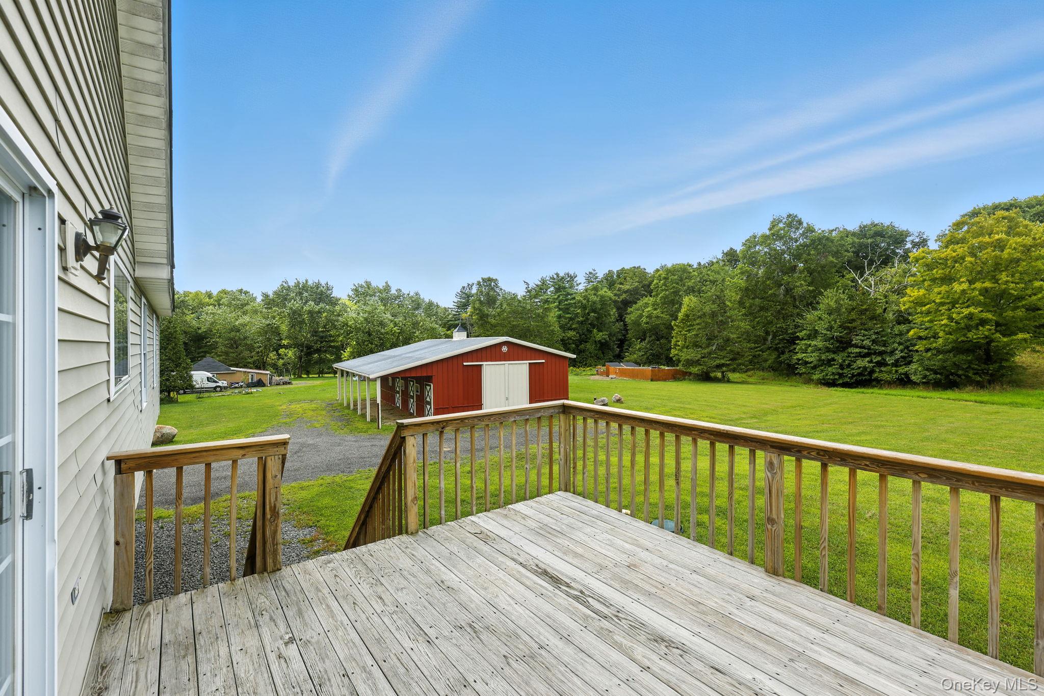 160 Pirog Road Pine Bush, NY 12566 - Photo 24 of 26 Wooden deck featuring a yard, a garage, gravel driveway, an outbuilding, and view of wooded area