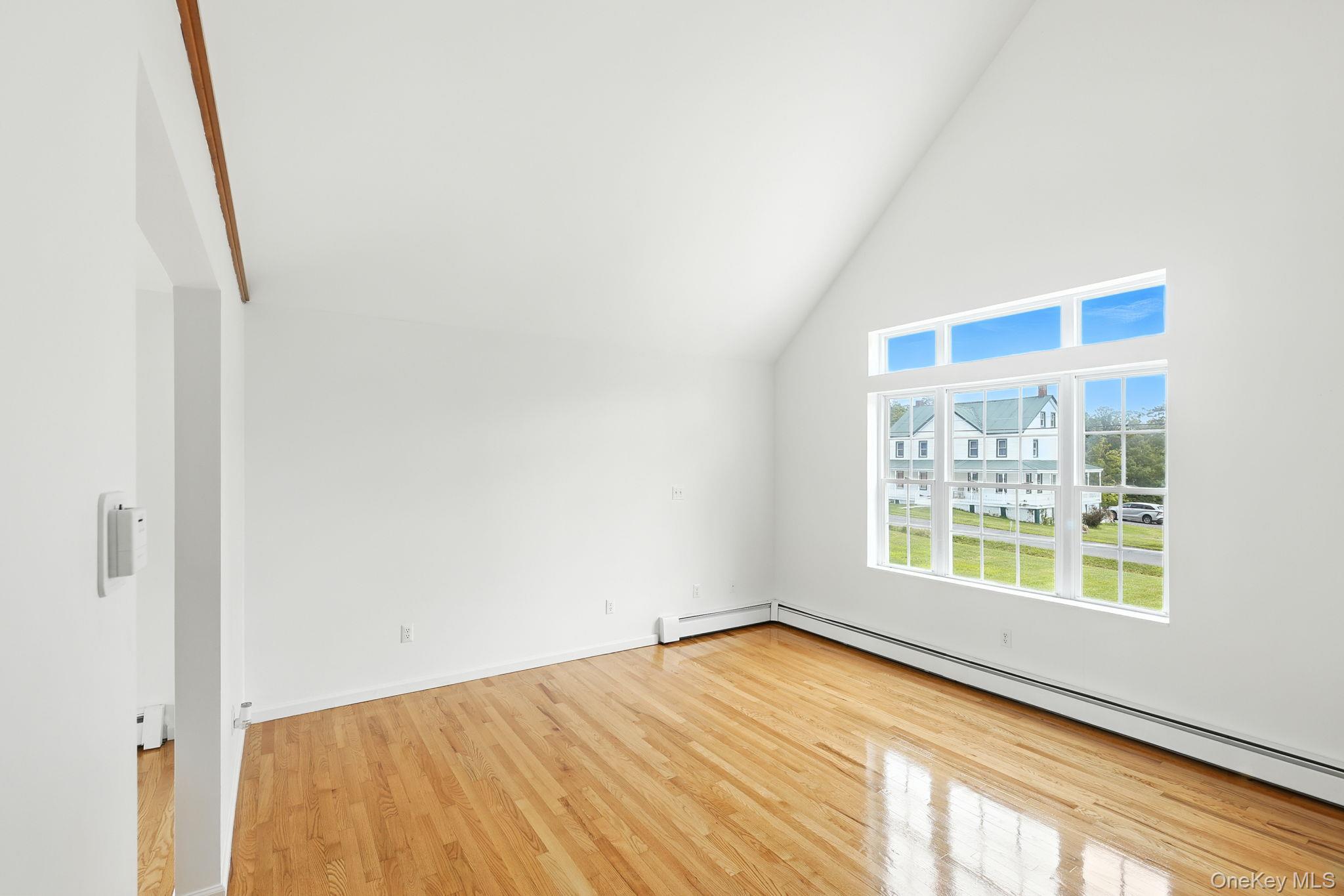 160 Pirog Road Pine Bush, NY 12566 - Photo 9 of 26 Additional living space with high vaulted ceiling, light wood-style floors, and a baseboard heating unit