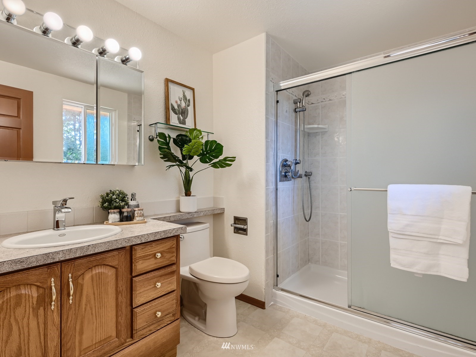 904 9th Street Snohomish, WA 98290 - Photo 14 of 40 a bathroom with a granite countertop sink a toilet a mirror and shower