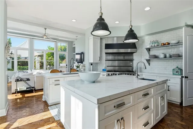 a kitchen with stainless steel appliances granite countertop a sink a stove and a wooden floors