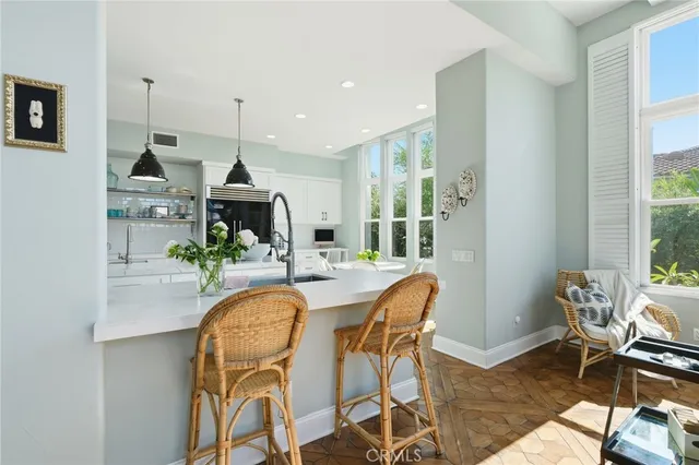 a dining room with furniture potted plants and wooden floor