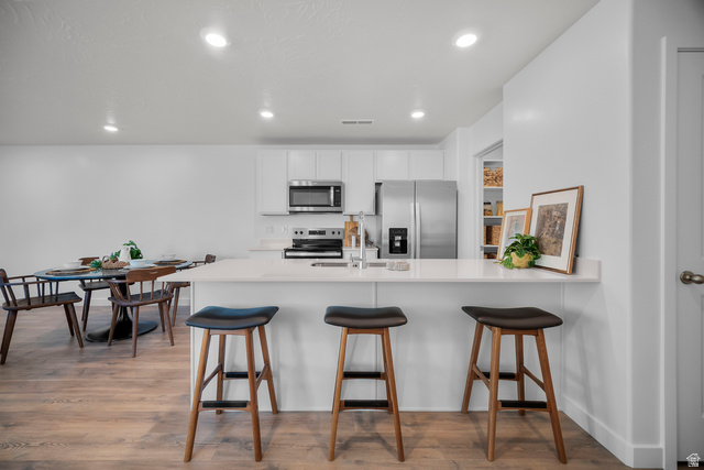 2202 Wolverine Way, Unit 2529 Washington, UT 84780 - Photo 8 of 27 Kitchen featuring white cabinetry, stainless steel appliances, a white countertop island with seating, and recessed lighting