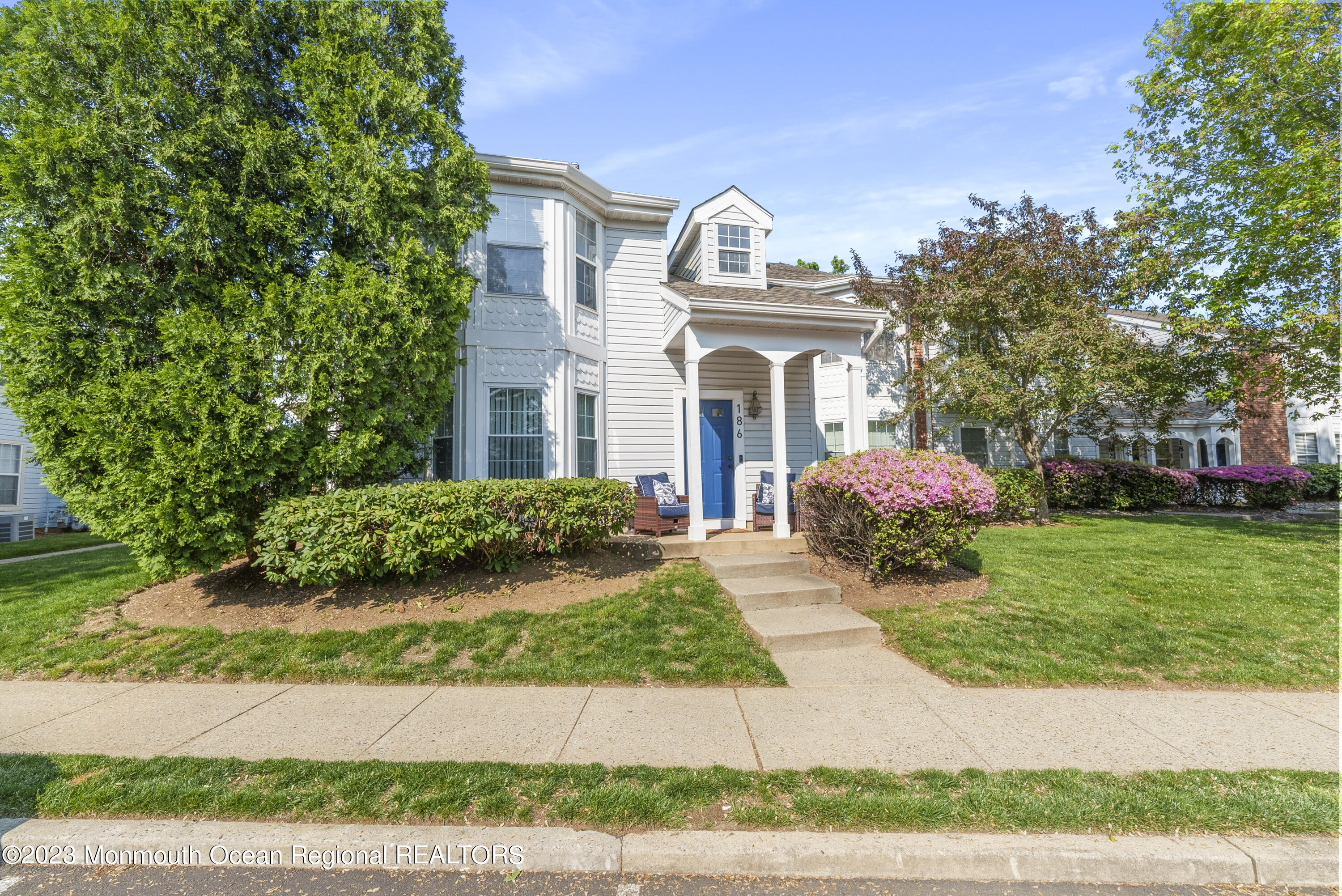 a front view of a house with a garden and plants