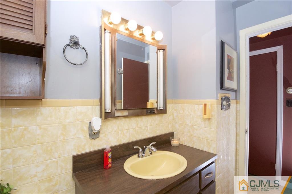 71 South Pennington Road New Brunswick, NJ 08901 - Photo 12 of 24 a bathroom with a sink vanity and a mirror