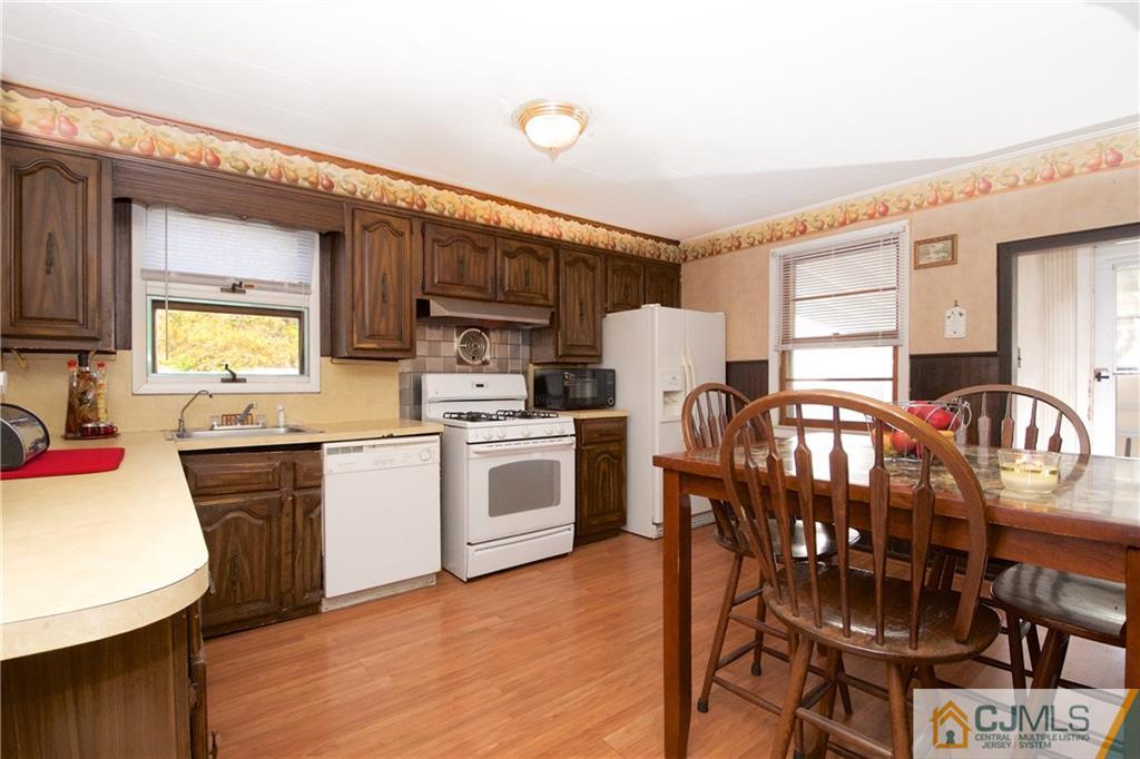 71 South Pennington Road New Brunswick, NJ 08901 - Photo 5 of 24 a kitchen with granite countertop a stove a sink dishwasher a refrigerator with a dining table and chairs with wooden floor