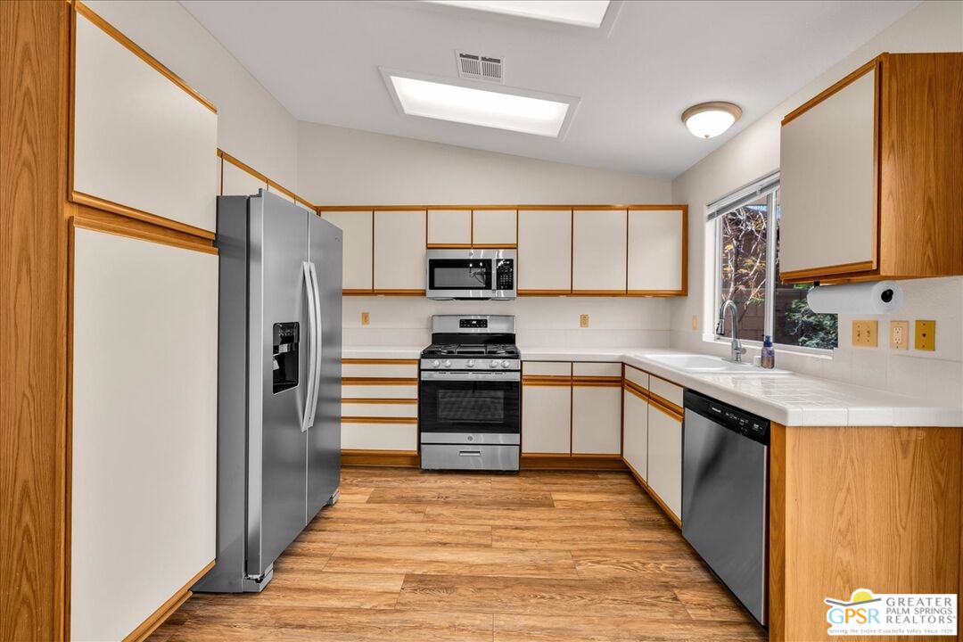 68130 Hermosillo Road Cathedral City, CA 92234 - Photo 17 of 49 a kitchen with granite countertop a refrigerator and a stove