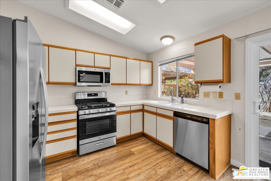 68130 Hermosillo Road Cathedral City, CA 92234 - Photo 18 of 49 a kitchen with a sink cabinets stainless steel appliances and a window