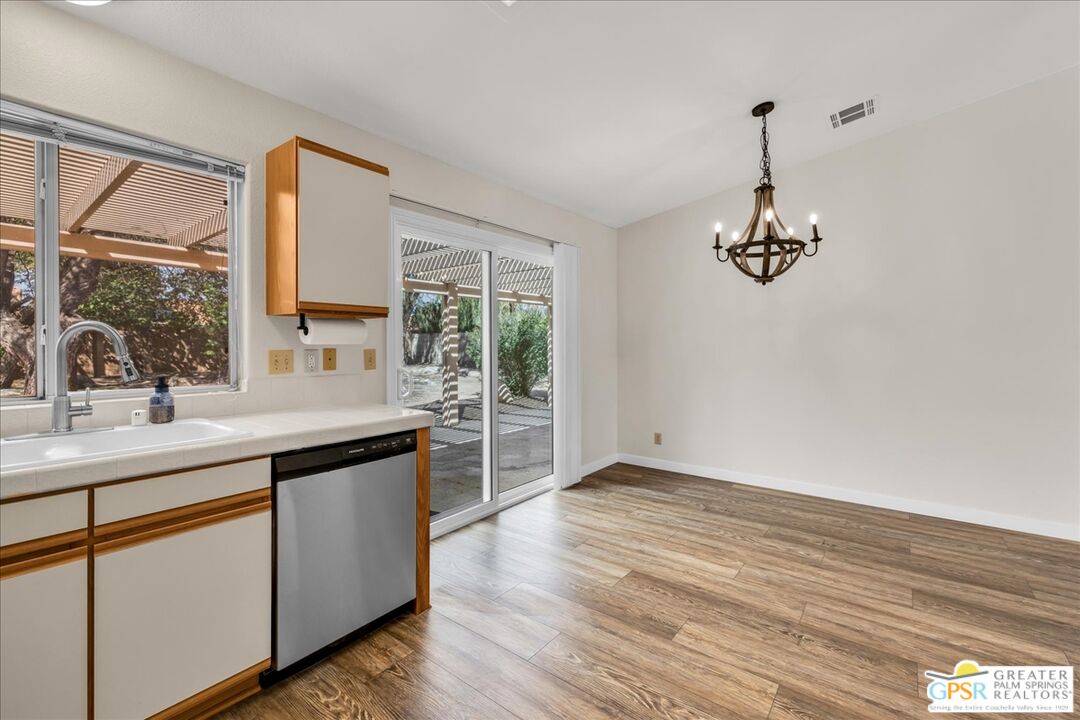 68130 Hermosillo Road Cathedral City, CA 92234 - Photo 19 of 49 a kitchen with stainless steel appliances granite countertop a sink a stove and a wooden floors