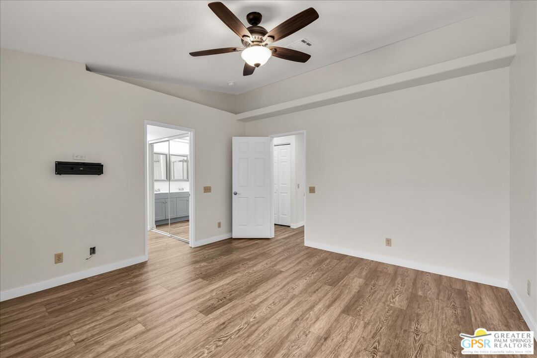 68130 Hermosillo Road Cathedral City, CA 92234 - Photo 21 of 49 an empty room with wooden floor and a ceiling fan