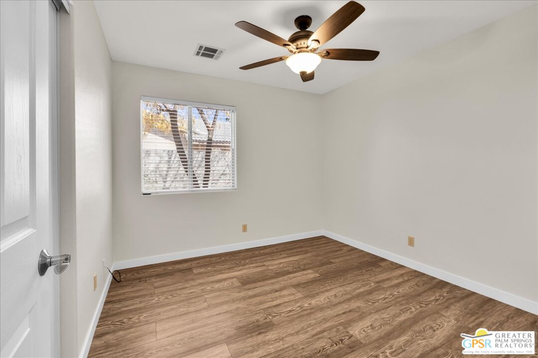 68130 Hermosillo Road Cathedral City, CA 92234 - Photo 32 of 49 an empty room with wooden floor fan and windows