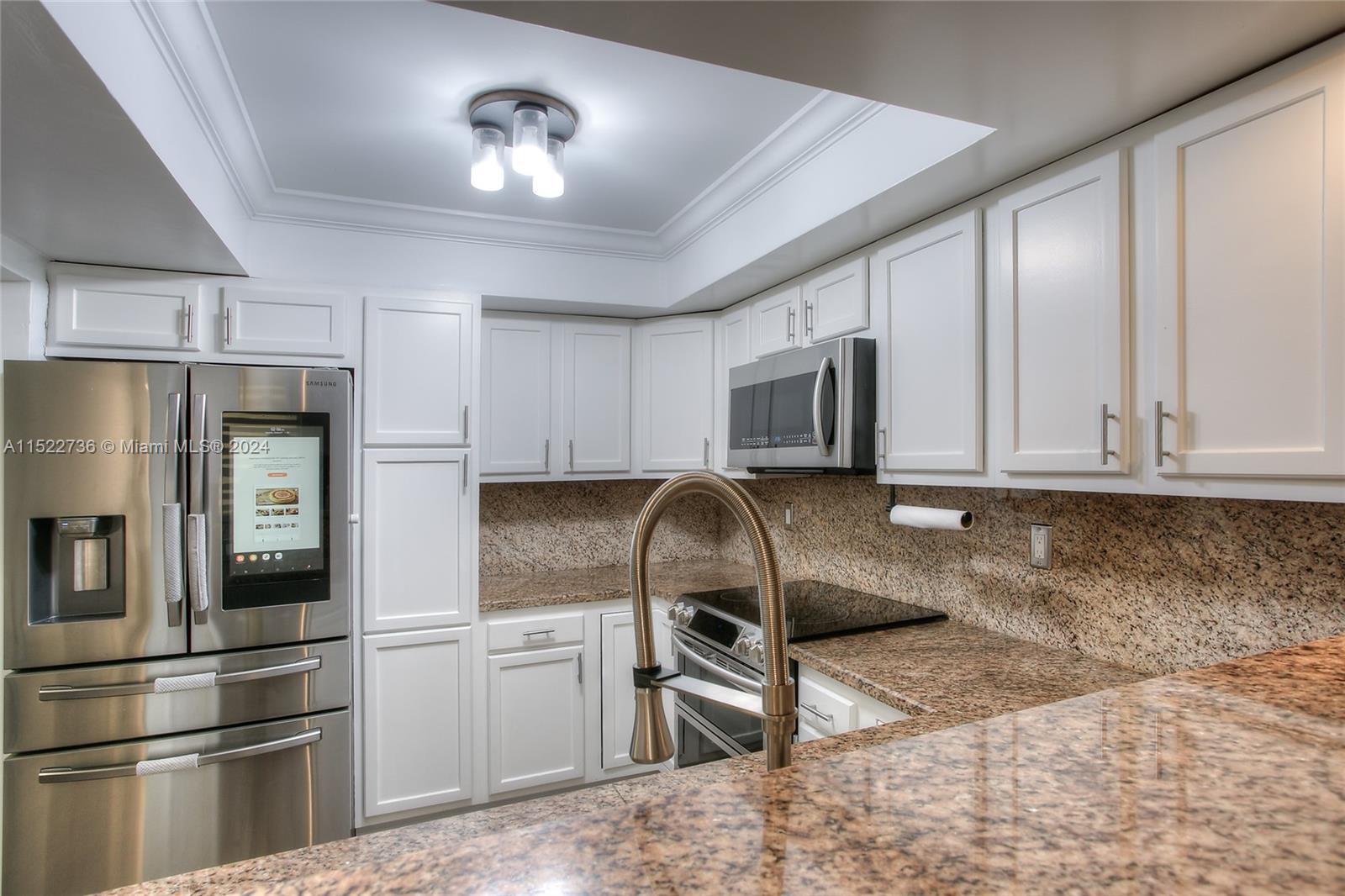 8401 West Sample Road, Unit 35 Coral Springs, FL 33065 - Photo 3 of 13 a kitchen with stainless steel appliances granite countertop a refrigerator a stove top oven a sink and dishwasher