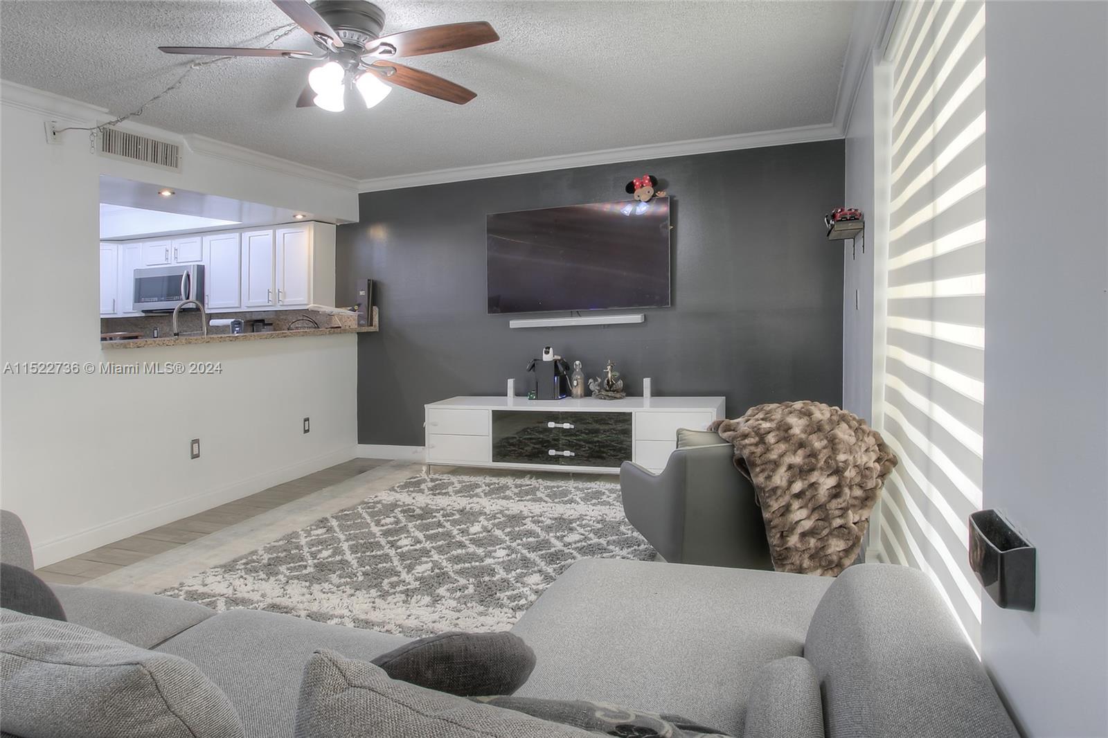 8401 West Sample Road, Unit 35 Coral Springs, FL 33065 - Photo 5 of 13 a living room with furniture and a flat screen tv