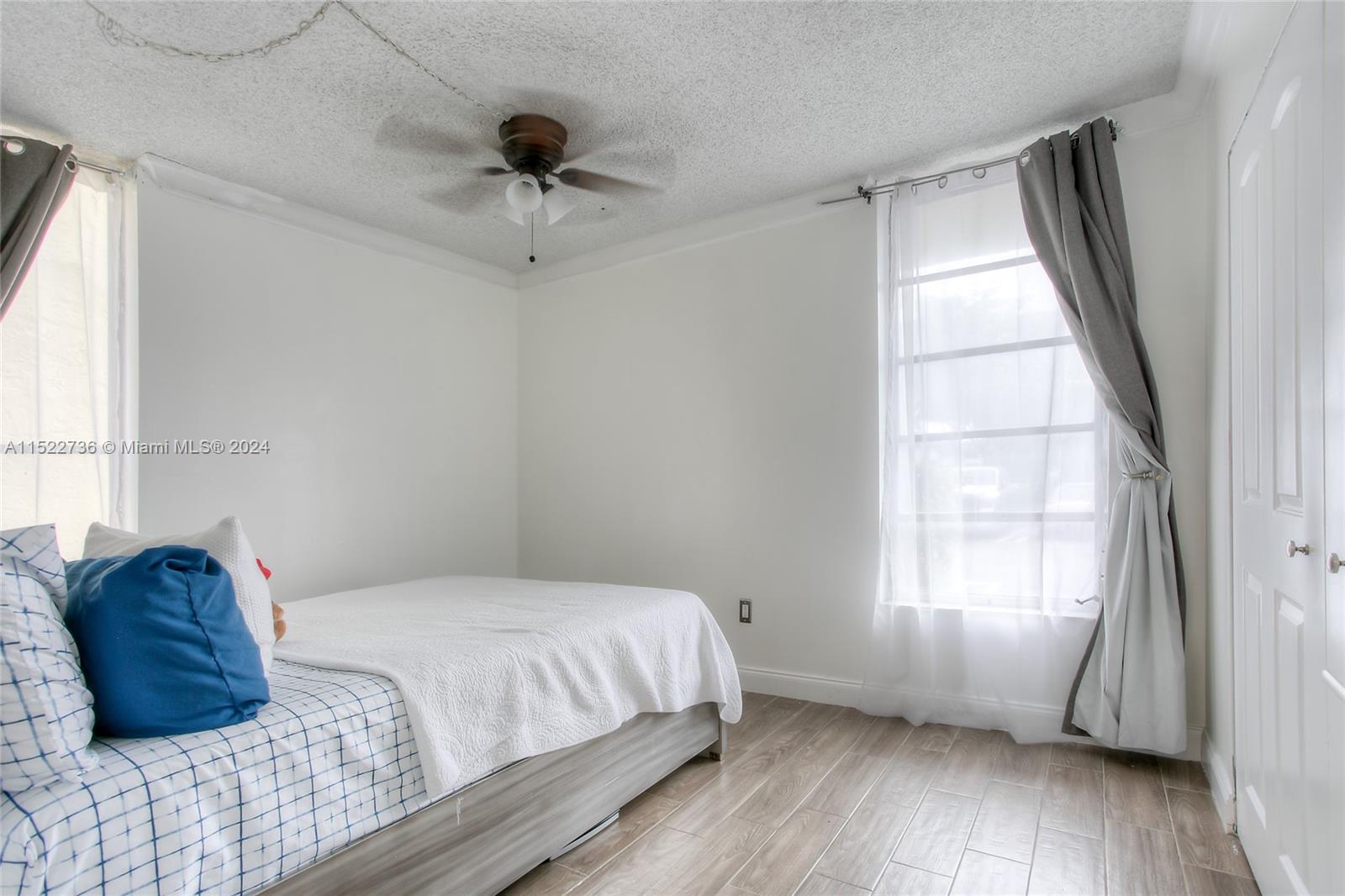 8401 West Sample Road, Unit 35 Coral Springs, FL 33065 - Photo 7 of 13 a bedroom with a bed and a large window