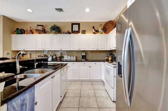 a kitchen with stainless steel appliances granite countertop a refrigerator and a stove