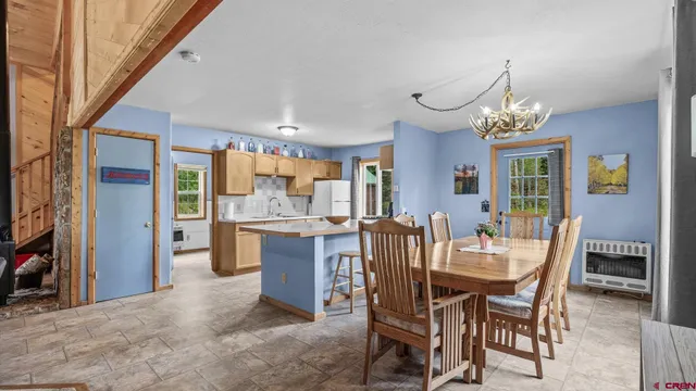 a view of a dining room with furniture and a chandelier