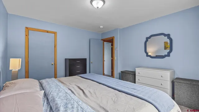 a bedroom with a bed and painting on the wall