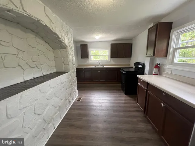 a large kitchen with kitchen island wooden floors and a sink