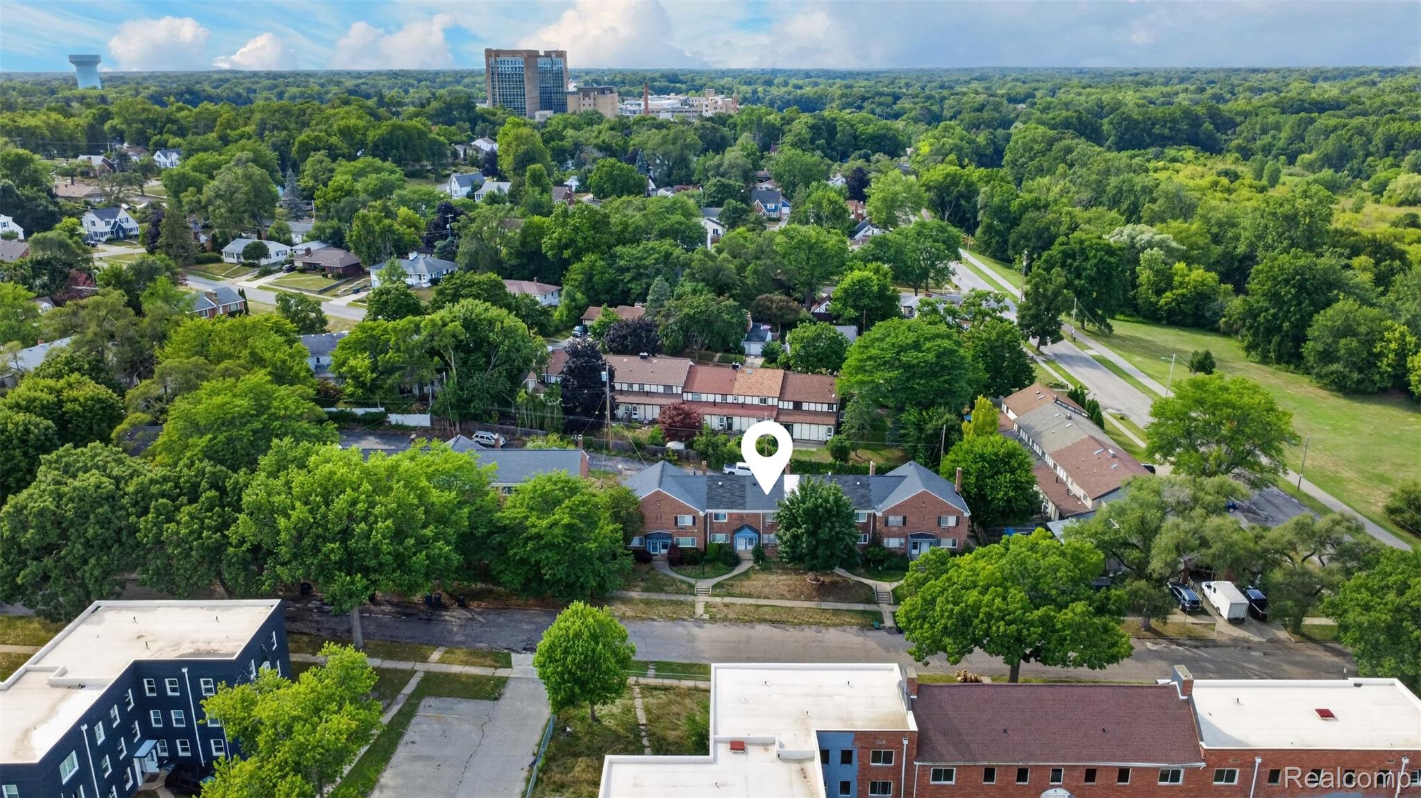 316 Sheffield Avenue Flint, MI 48503 - Photo 31 of 37 Aerial perspective showcasing a residential area with mature trees, established properties, a multi-lane roadway, and urban infrastructure in the distance
