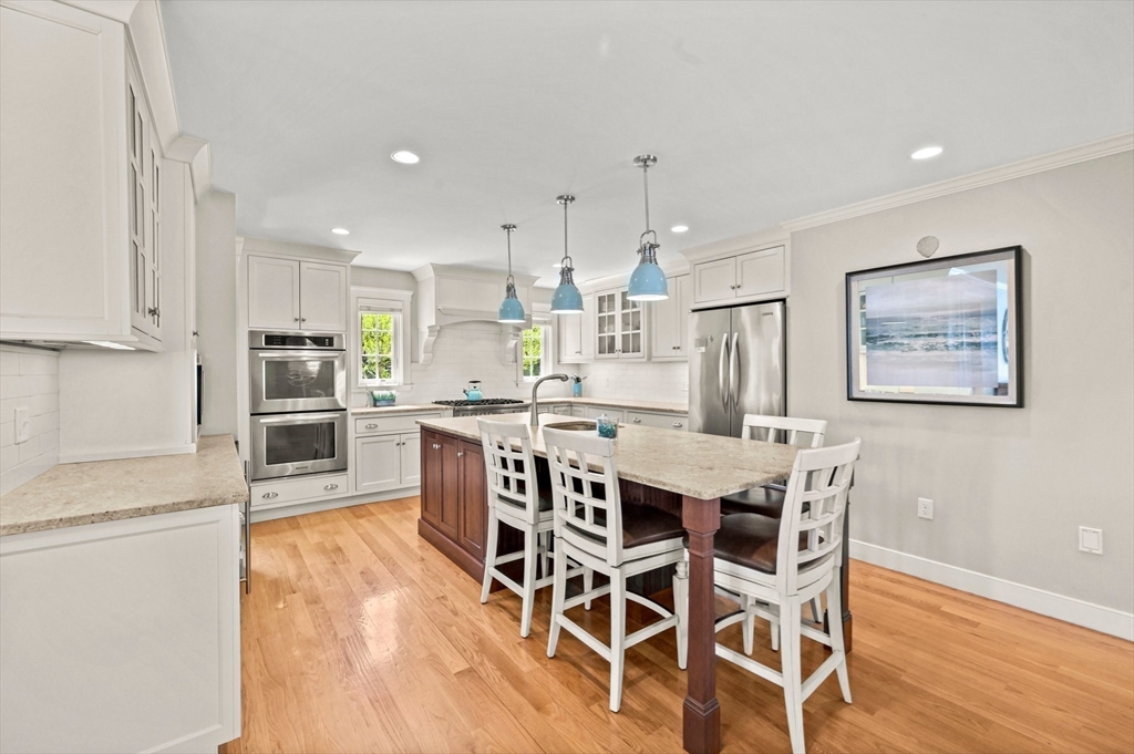 11 Whites Ferry Landing Marshfield, MA 02050 - Photo 16 of 42 a kitchen with stainless steel appliances kitchen island granite countertop a wooden floor and white cabinets