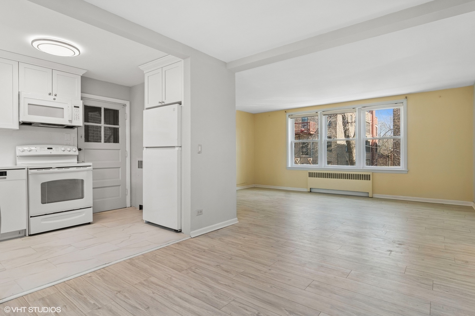 1143 East 50th Street, Unit 2 Chicago, IL 60615 - Photo 12 of 29 a view of a kitchen with a stove cabinets a ceiling fan and wooden floor