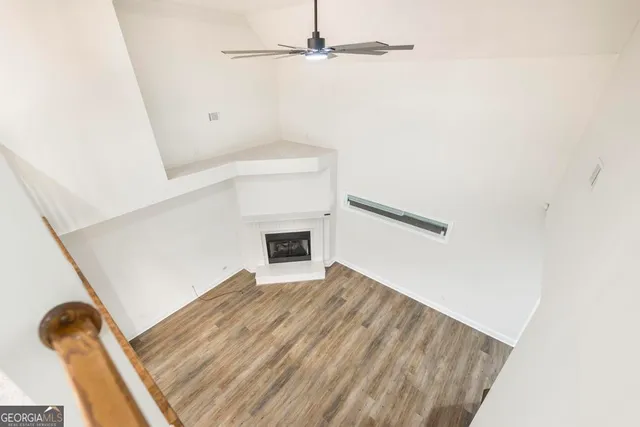 a view of a room with wooden floor and white walls