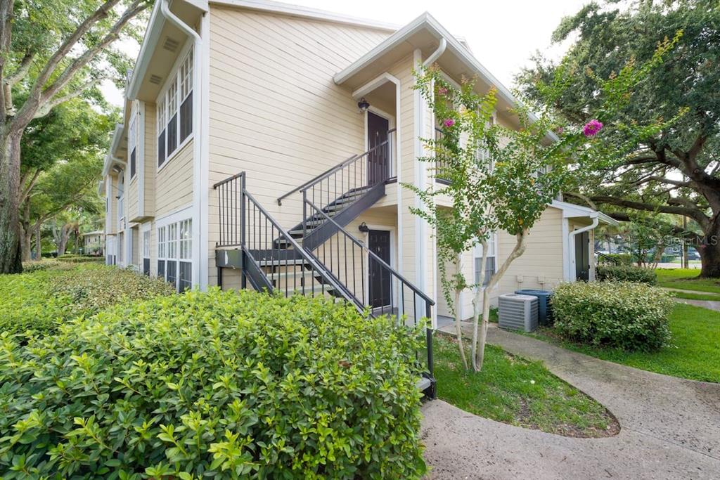 1027 South Hiawassee Road, Unit 2323 Orlando, FL 32835 - Photo 1 of 1 a view of a house with a small yard and plants
