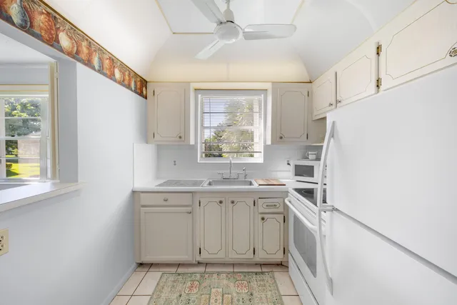 a kitchen with a sink a refrigerator and window