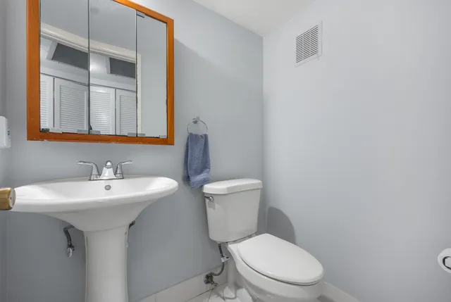 a white toilet sitting next to a bathroom sink