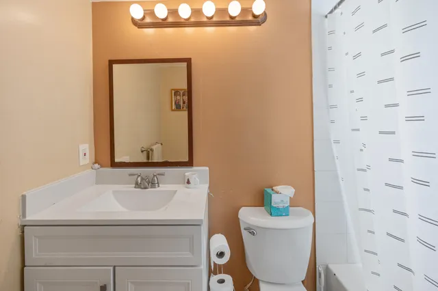 a bathroom with a sink a toilet and mirror