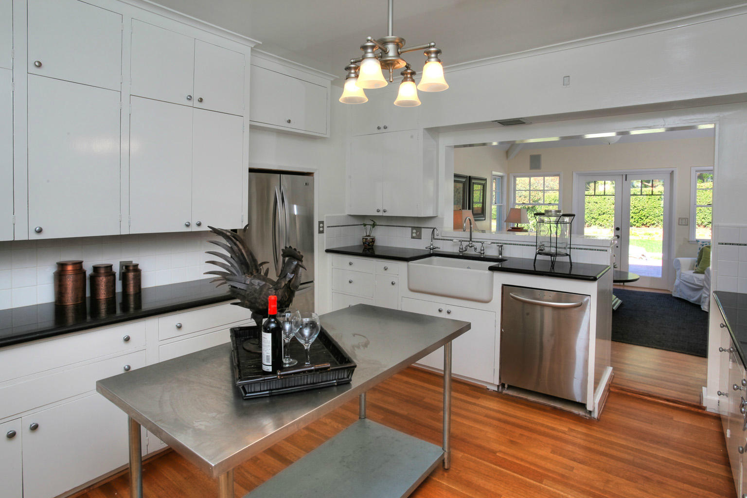 2135 Ridge Lane Santa Barbara, CA 93103 - Photo 5 of 15 a kitchen with a sink dishwasher a stove a dining table and chairs with wooden floor