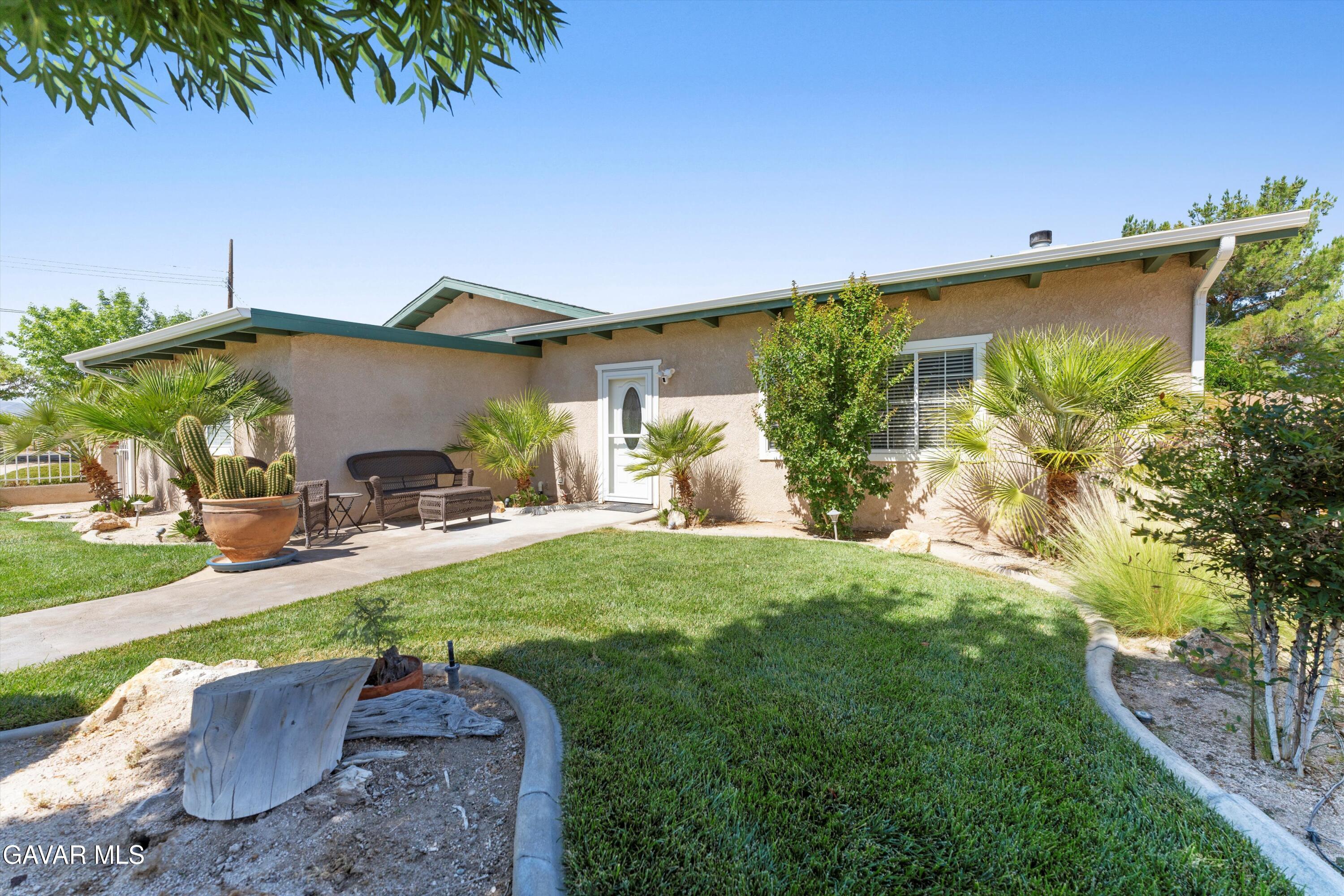 a view of a backyard with plants and a patio