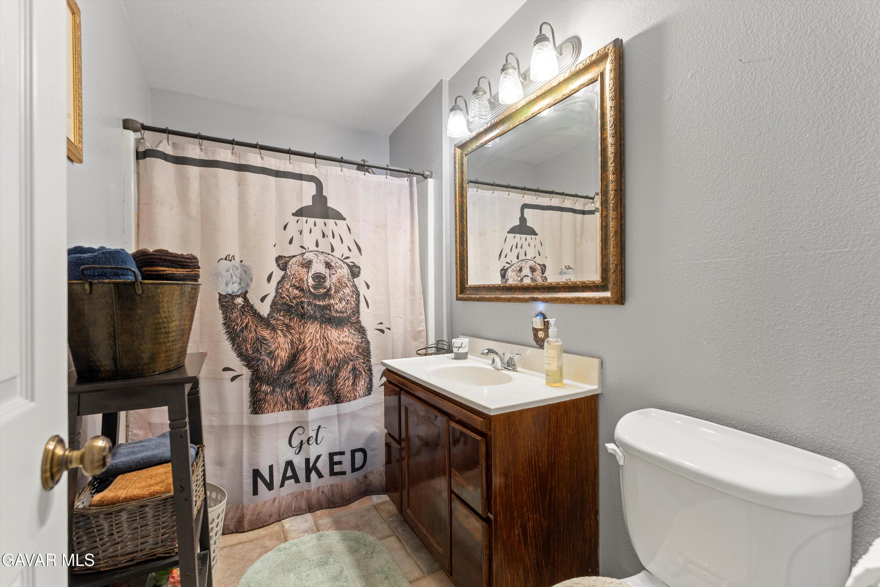 42409 12th Street West Lancaster, CA 93534 - Photo 12 of 20 a bathroom with a toilet sink and mirror