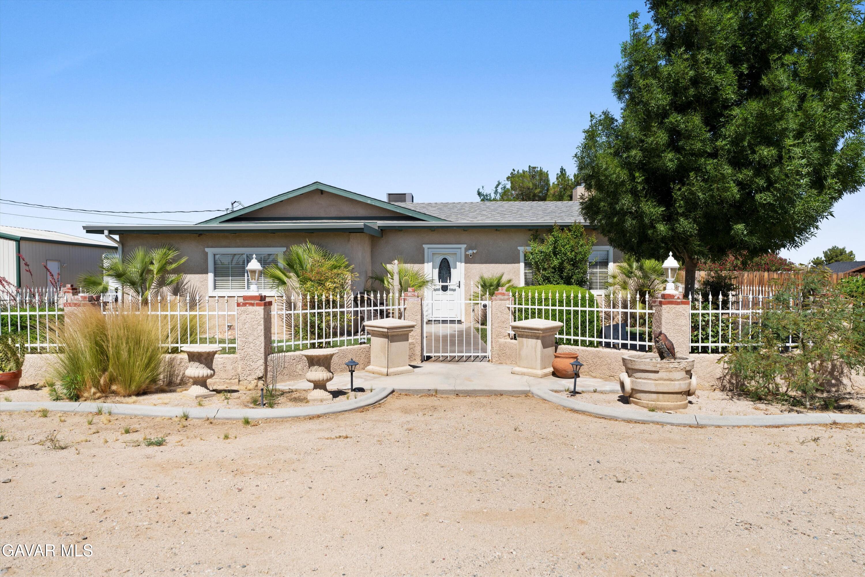 42409 12th Street West Lancaster, CA 93534 - Photo 2 of 20 a view of a patio with a table and chairs under an umbrella