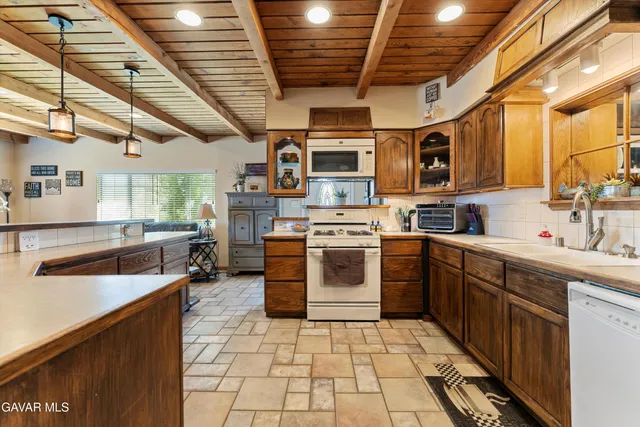 a kitchen with counter top space a sink appliances and cabinets