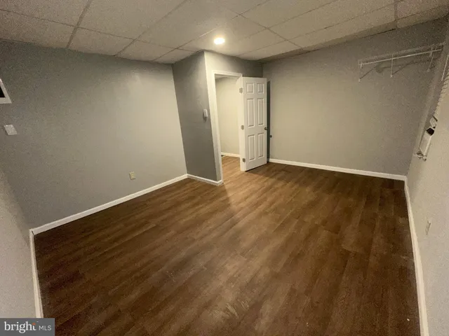 a view of a room with wooden floor and a bathroom
